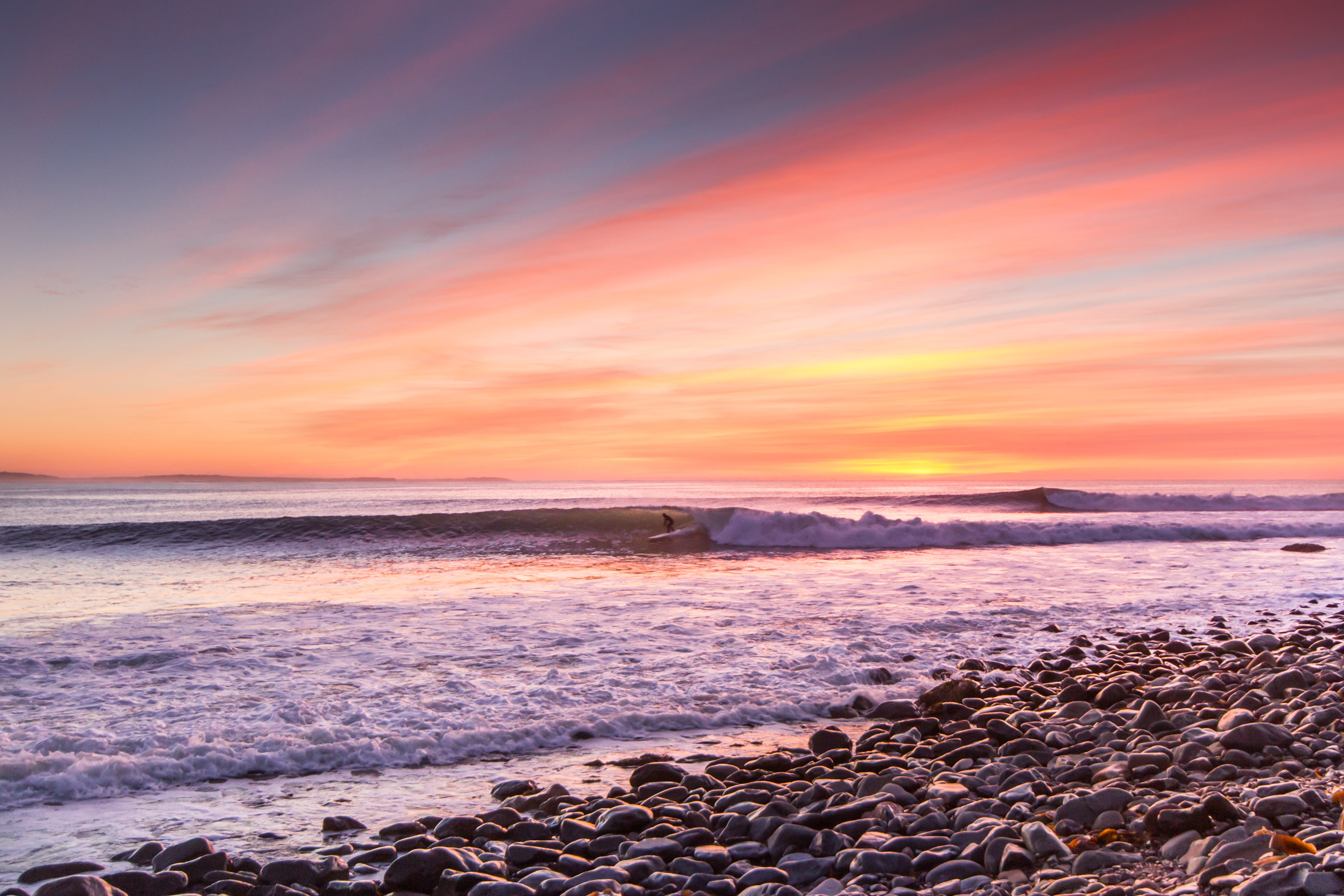 Pink and purple sunset over the ocean at Cow Bay