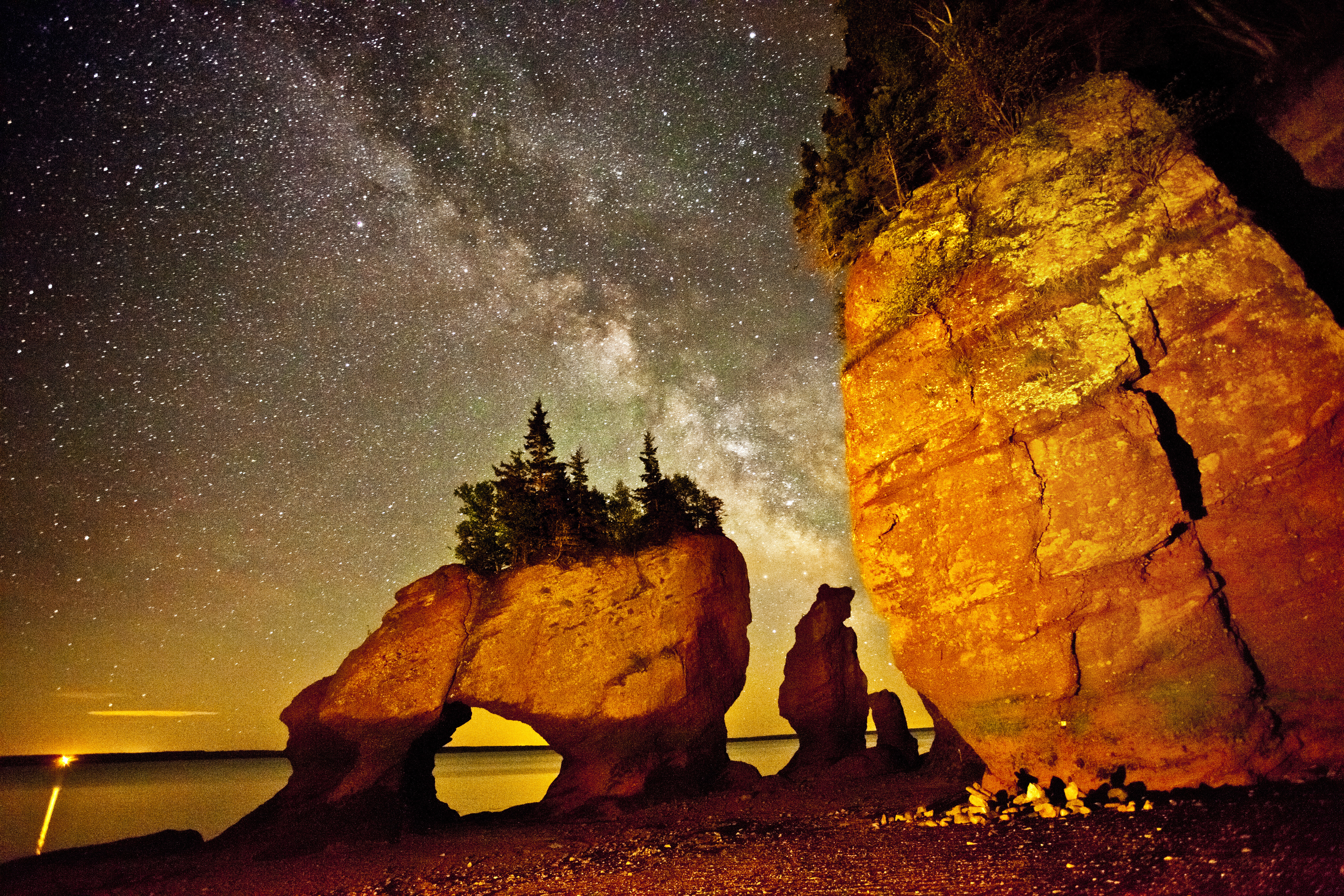 Hopewell Rocks carved sandstone sea stack rock formations tower over ocean floor on a starry night