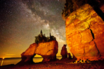 Hopewell Rocks carved sandstone sea stack rock formations tower over ocean floor on a starry night