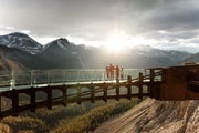 The sun peeks over the mountains and shines down onto the Glacier Skywalk.