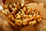 Poutine (fries, cheese curds and gravy) in a cardboard takeaway box