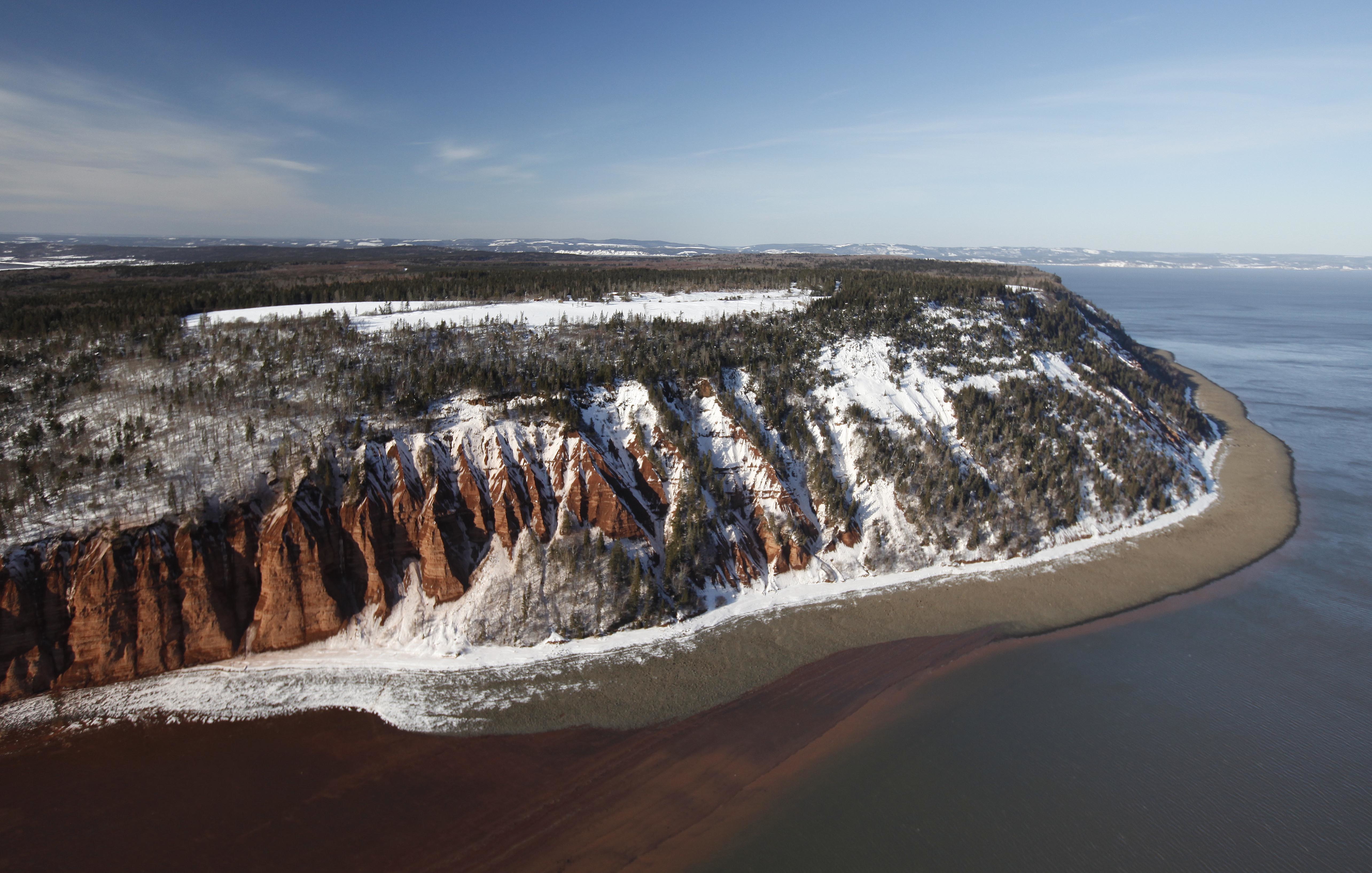 Snow on Cape Blomidon as tide nears shore at its foot