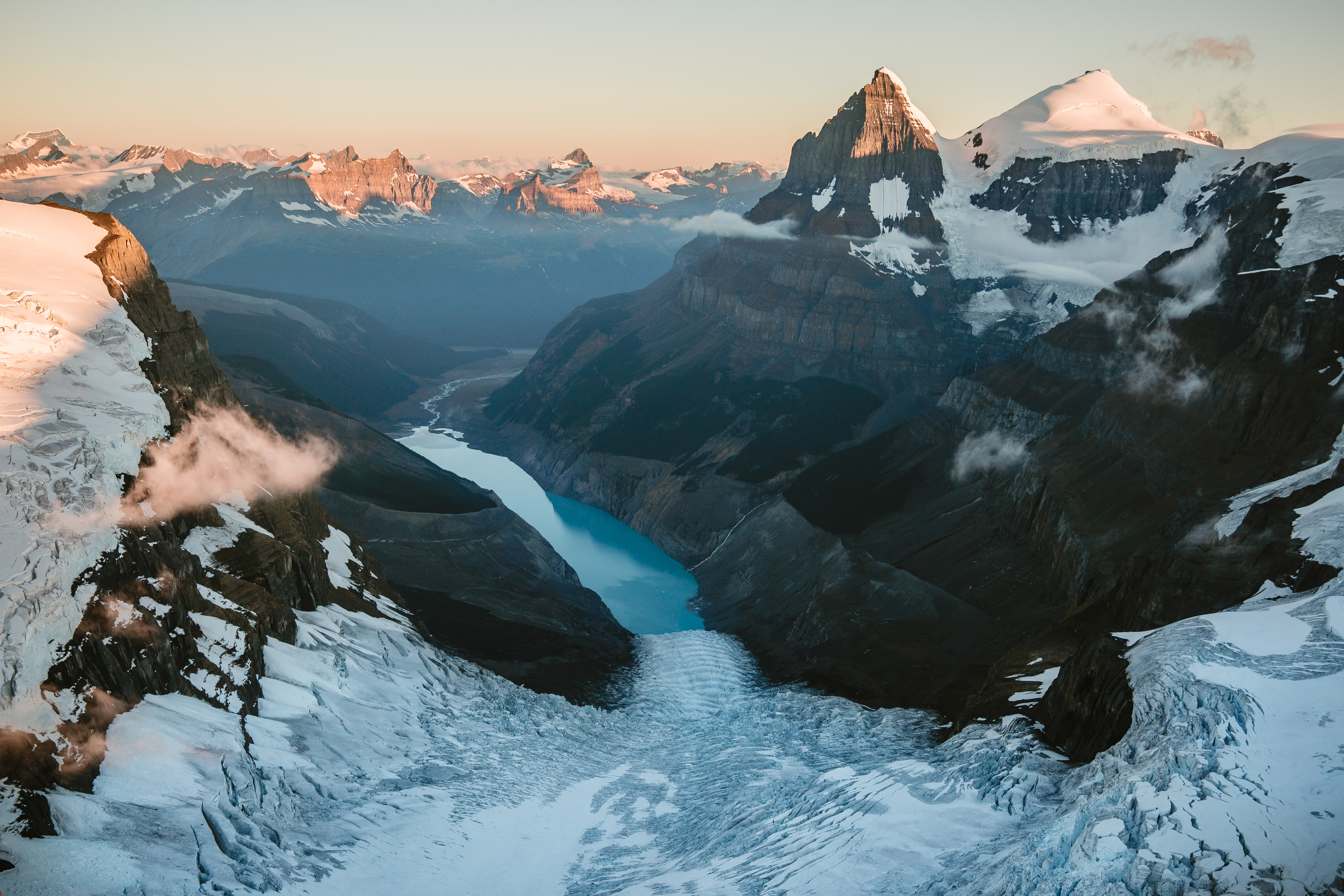 View of glacier mountain peaks and clear lake at sunset