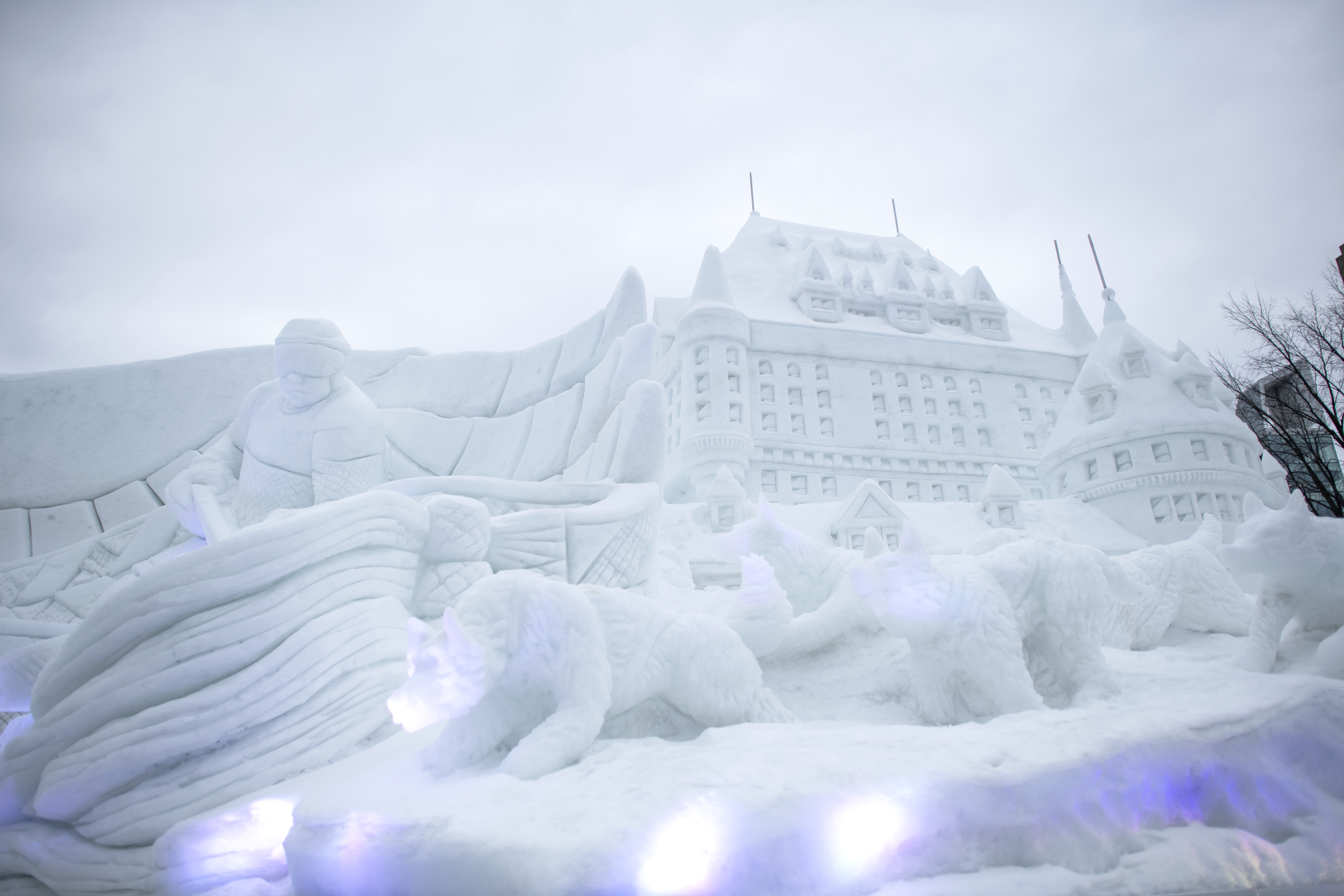 Large snow sculpture of Fairmont hotel, bears and person in canoe