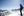 A skier standing at the top of a run looking at the snowy mountains ahead