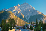 Banff Avenue, a busy street in Banff, is in front of towering mountains 