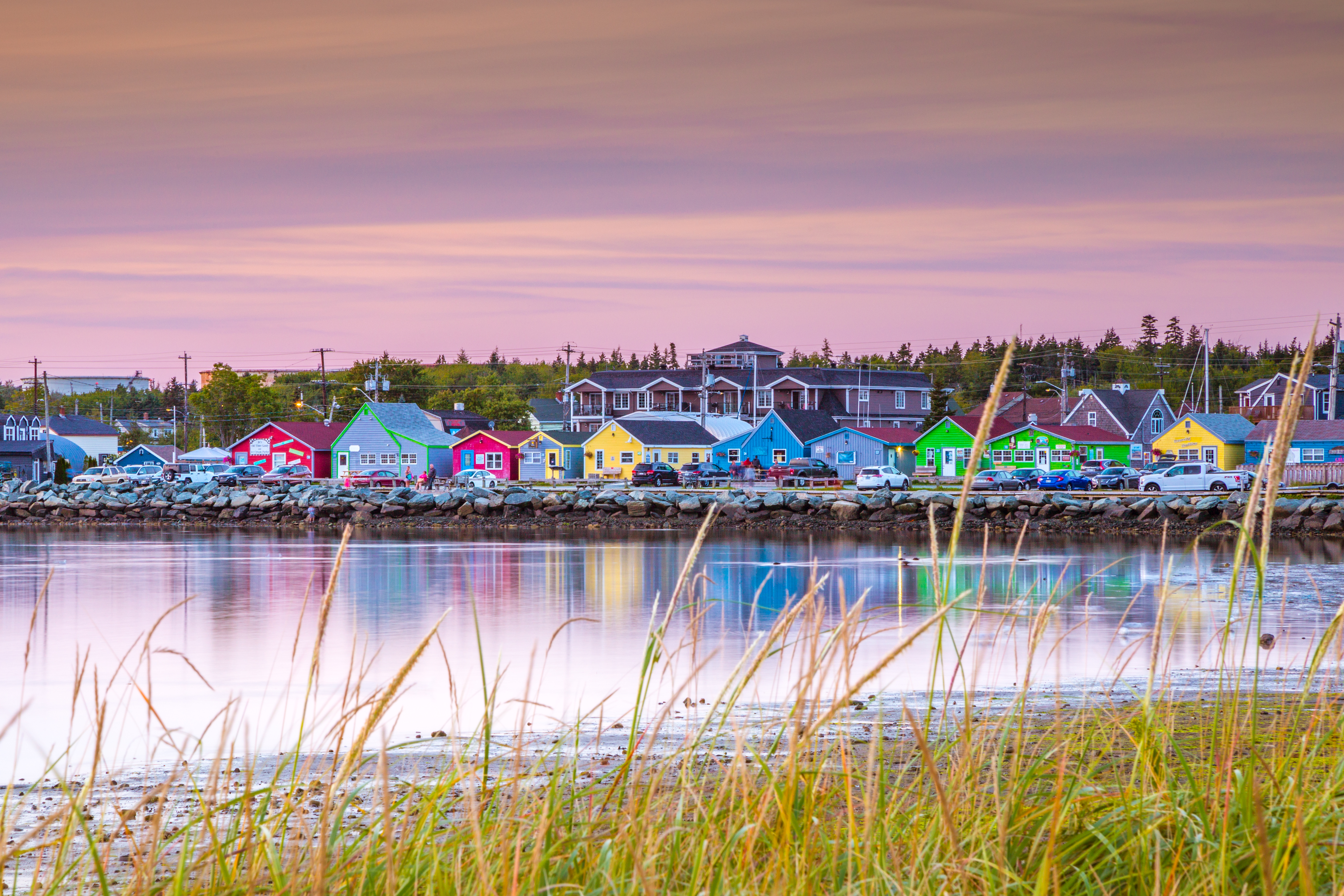 Row of colourful shops lined on boardwalk in restored fishing village