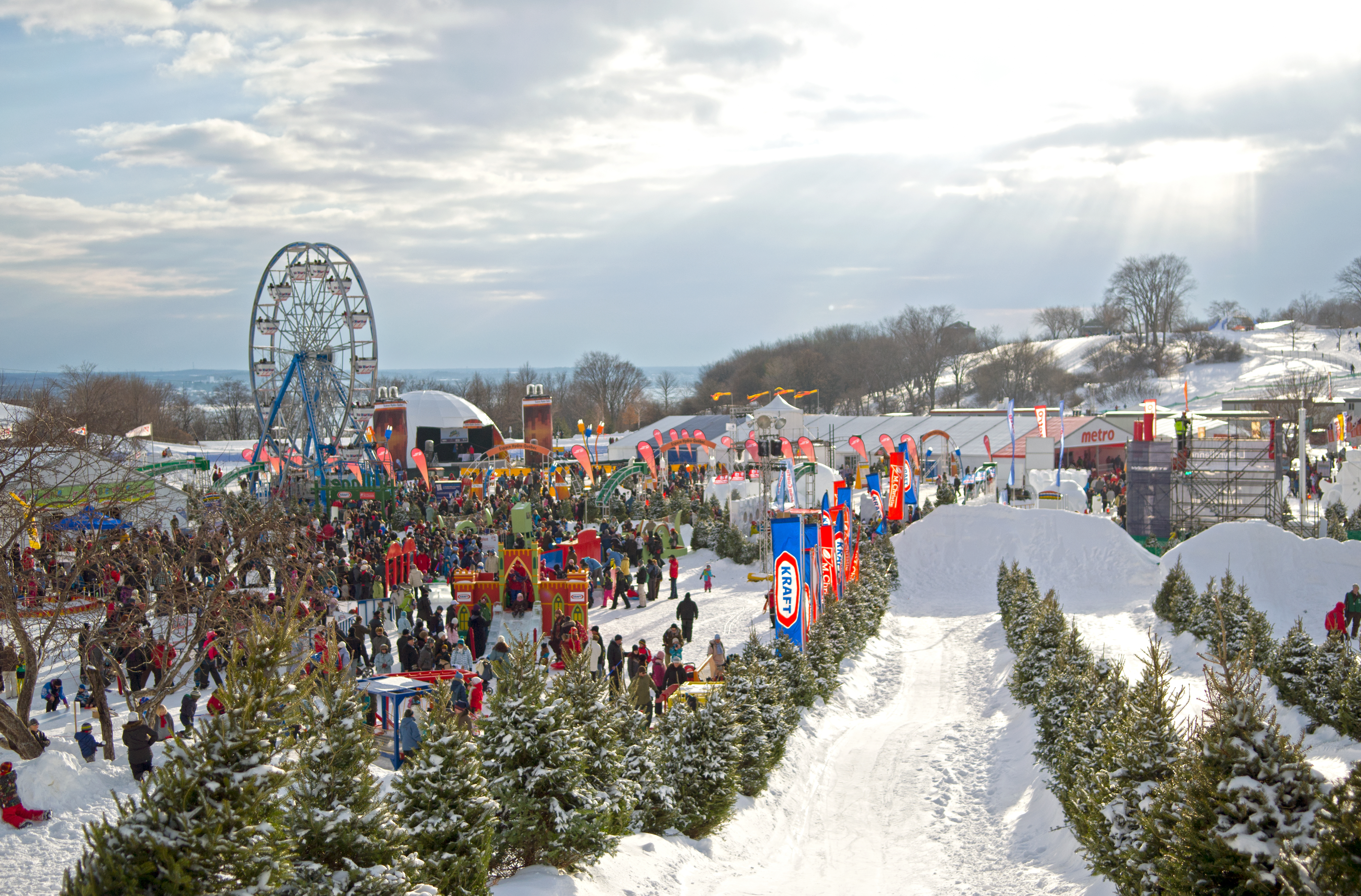 Small ferris wheel and fairground in the snow during the day at the Quebec Winter Carnival
