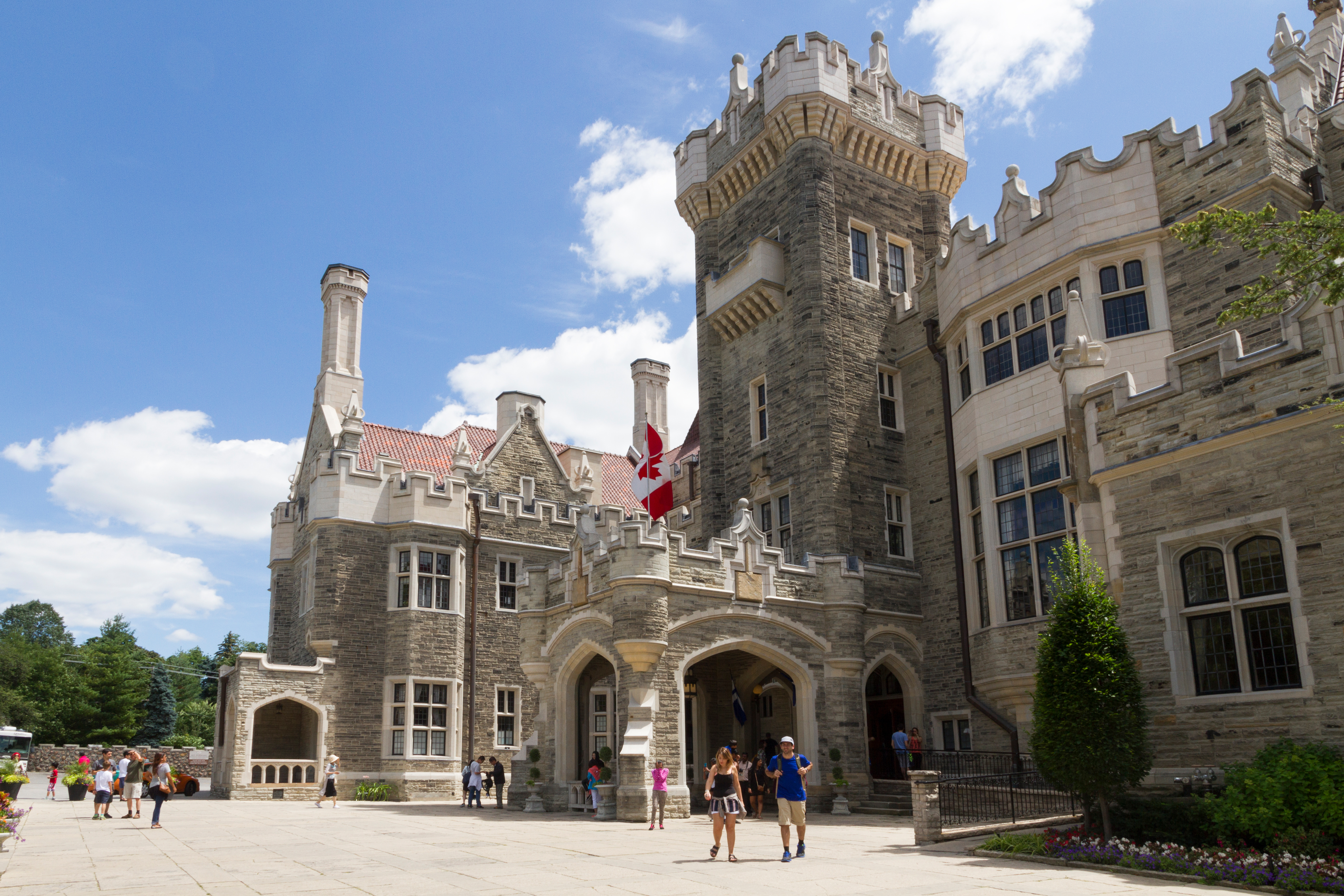 People walking near the entrance of Casa Loma, a castle-style mansion in Toronto