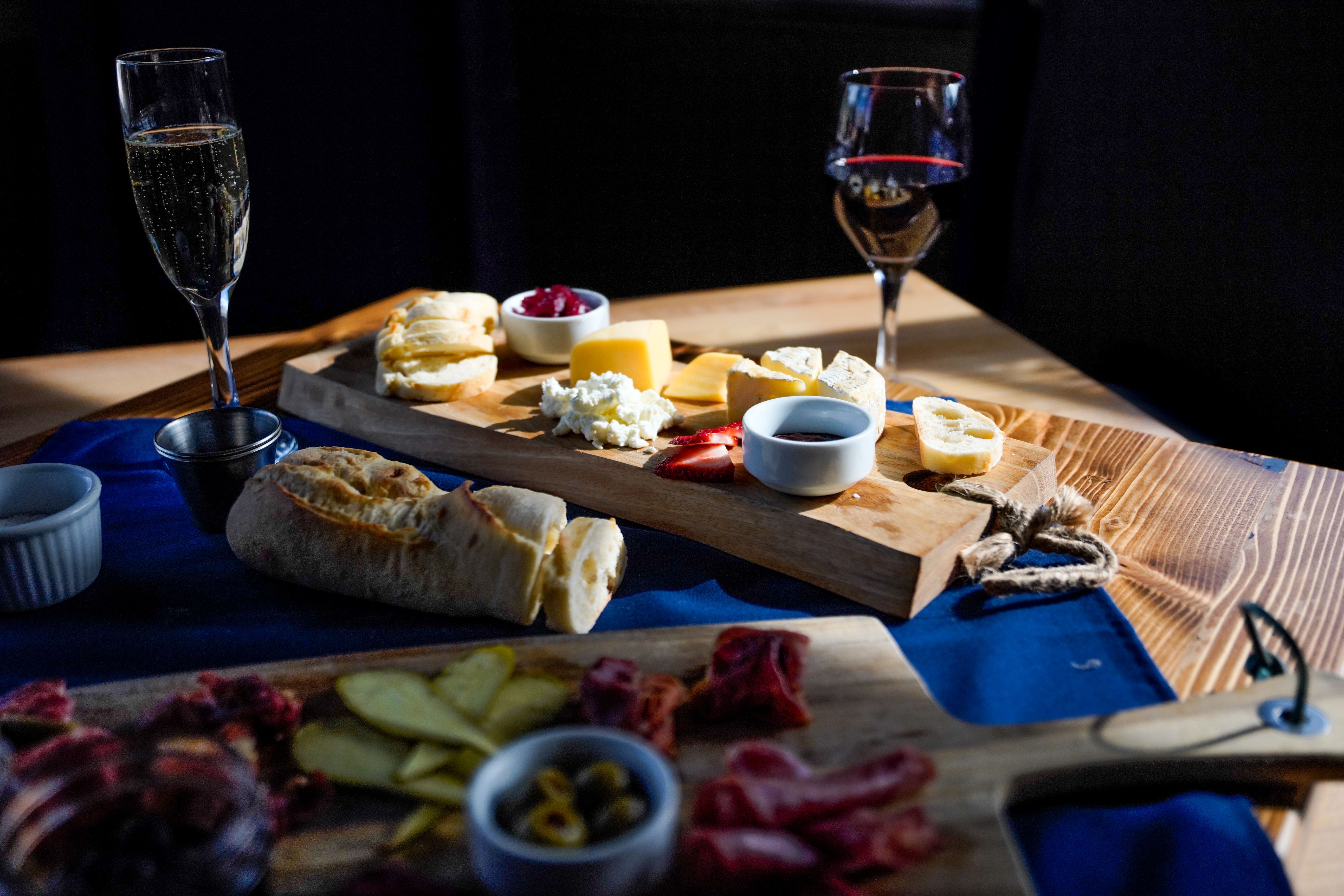 Charcuterie boards and alcoholic drinks on wooden table