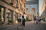 A woman walking her bike down a street in Old Montreal