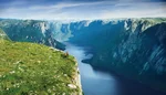hikers take in view near the edge of Western Brook Pond Fjord