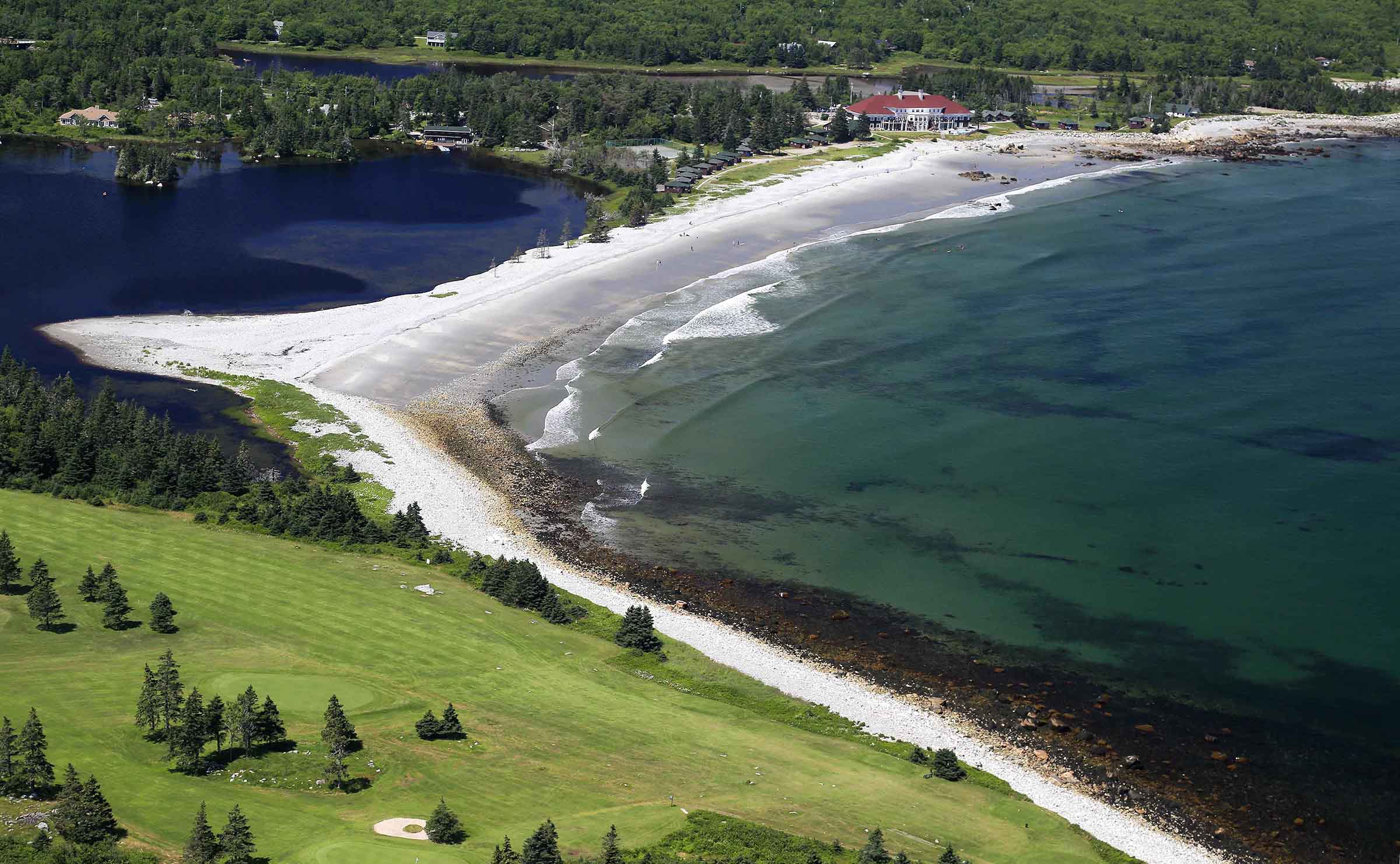Aerial view of White Point Beach Resort next to a white sand beach and clear blue ocean