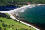 Aerial view of White Point Beach Resort next to white sand beach, ocean and golf course 