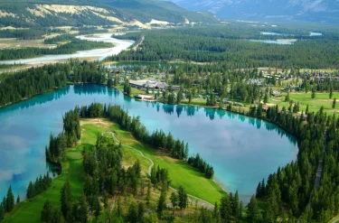 An aerial view of the Fairmont Jasper Park Lodge in summer, featuring the aqua-blue colours of Lac Beauvert.