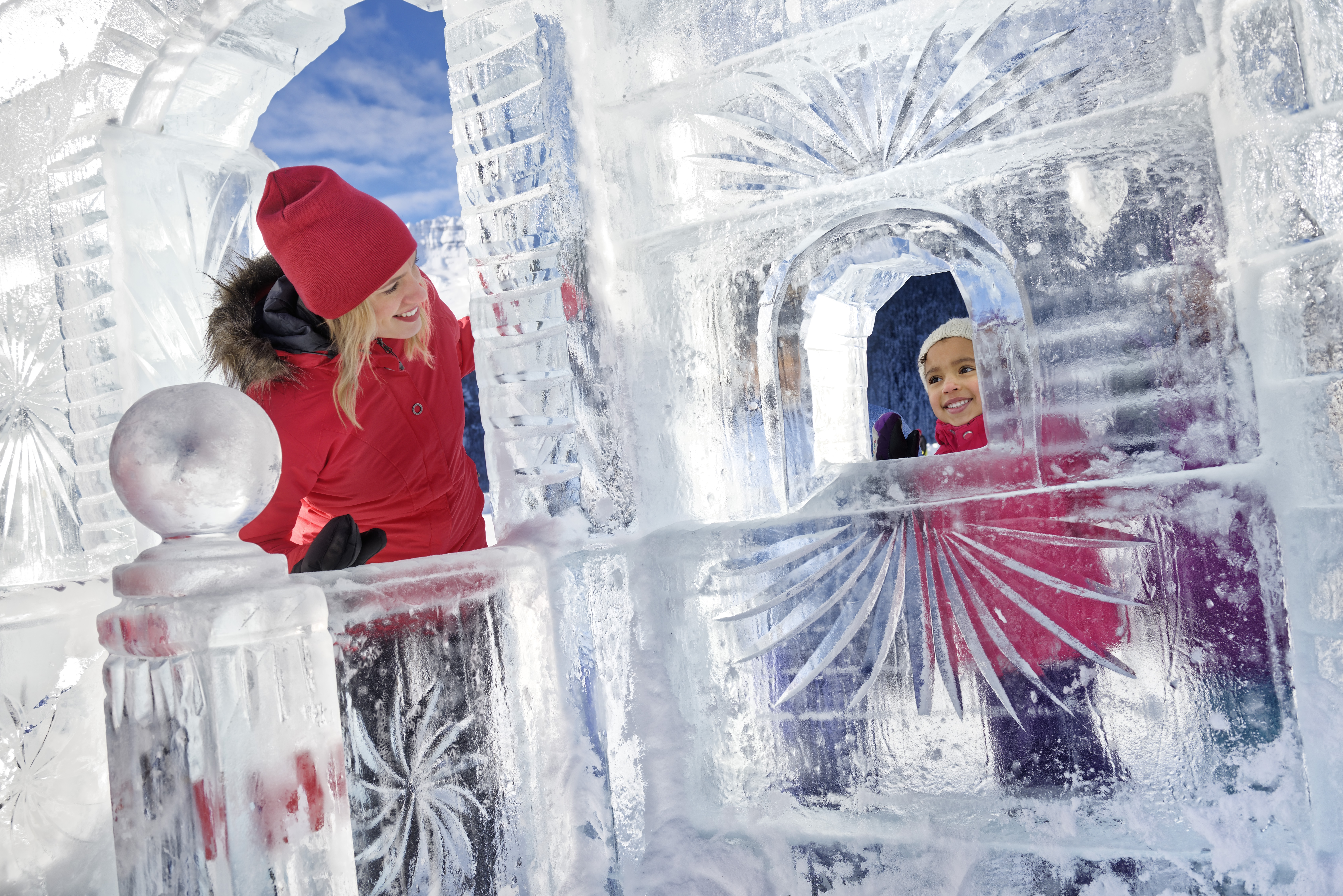 Family playing together on ice sculpture on frozen Lake Louise