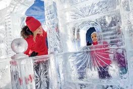 Family playing together on ice sculpture on frozen Lake Louise