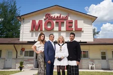 The cast of Schitt's Creek stand in front of the Rosebud Motel