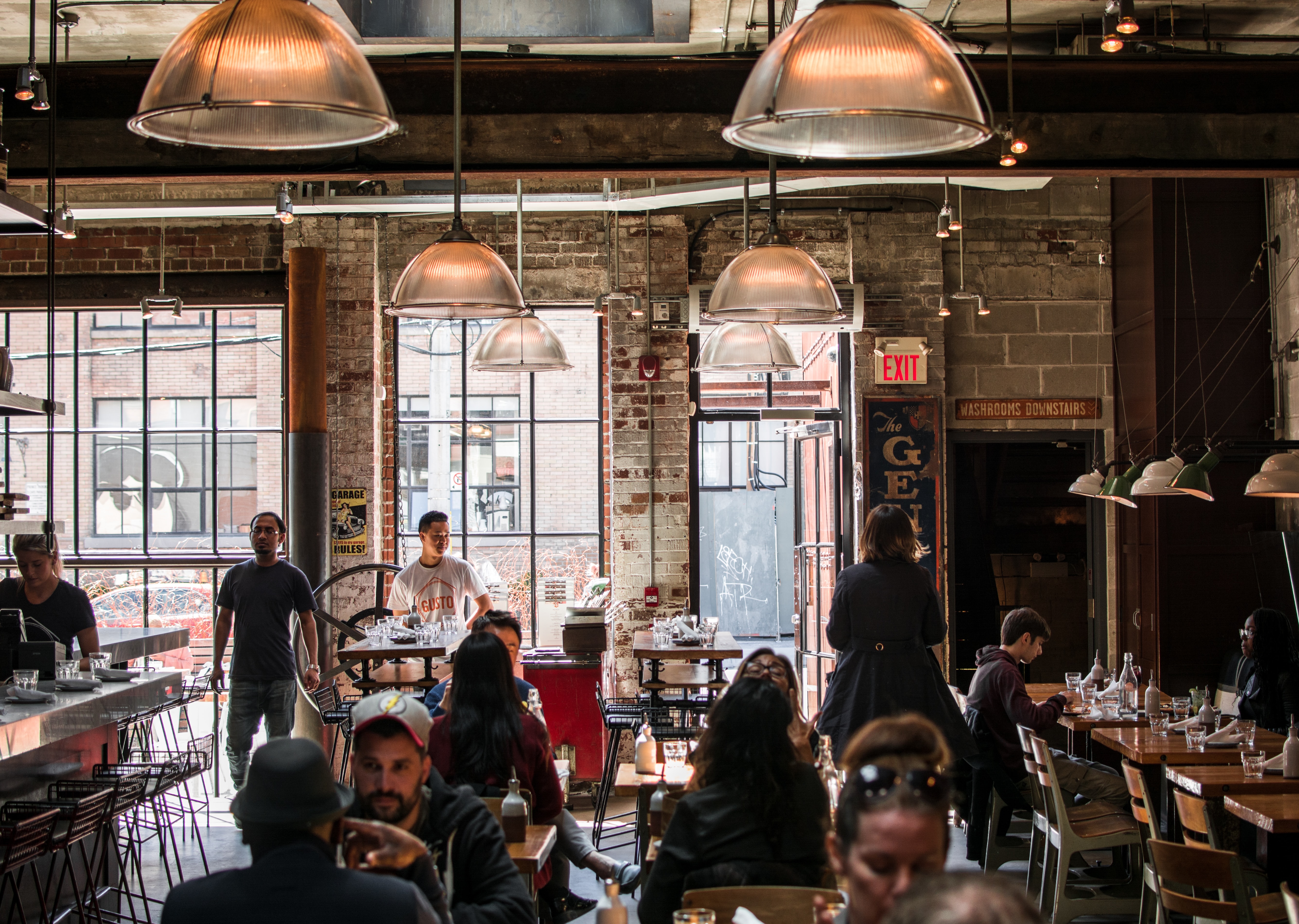 People sitting in a brick-walled coffee shop