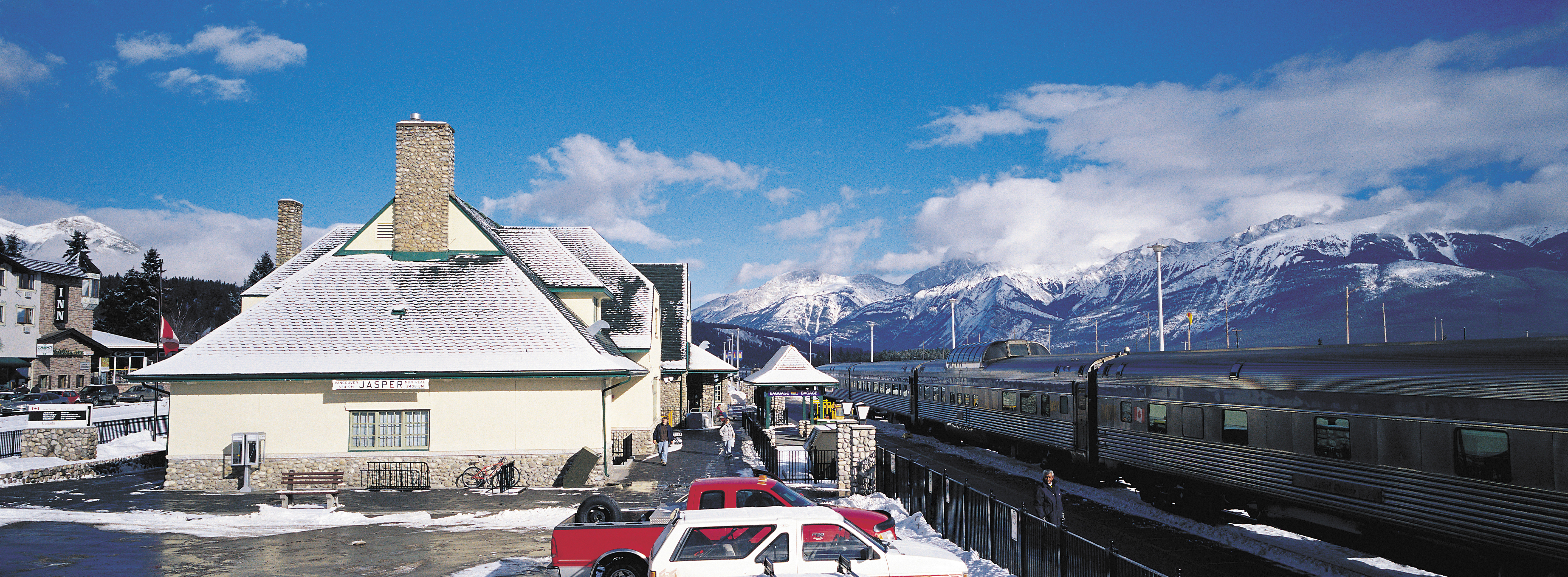 Outdoor train station after snow with view of mountains in the background
