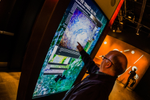Man touches a display screen inside the Montreal planetarium 