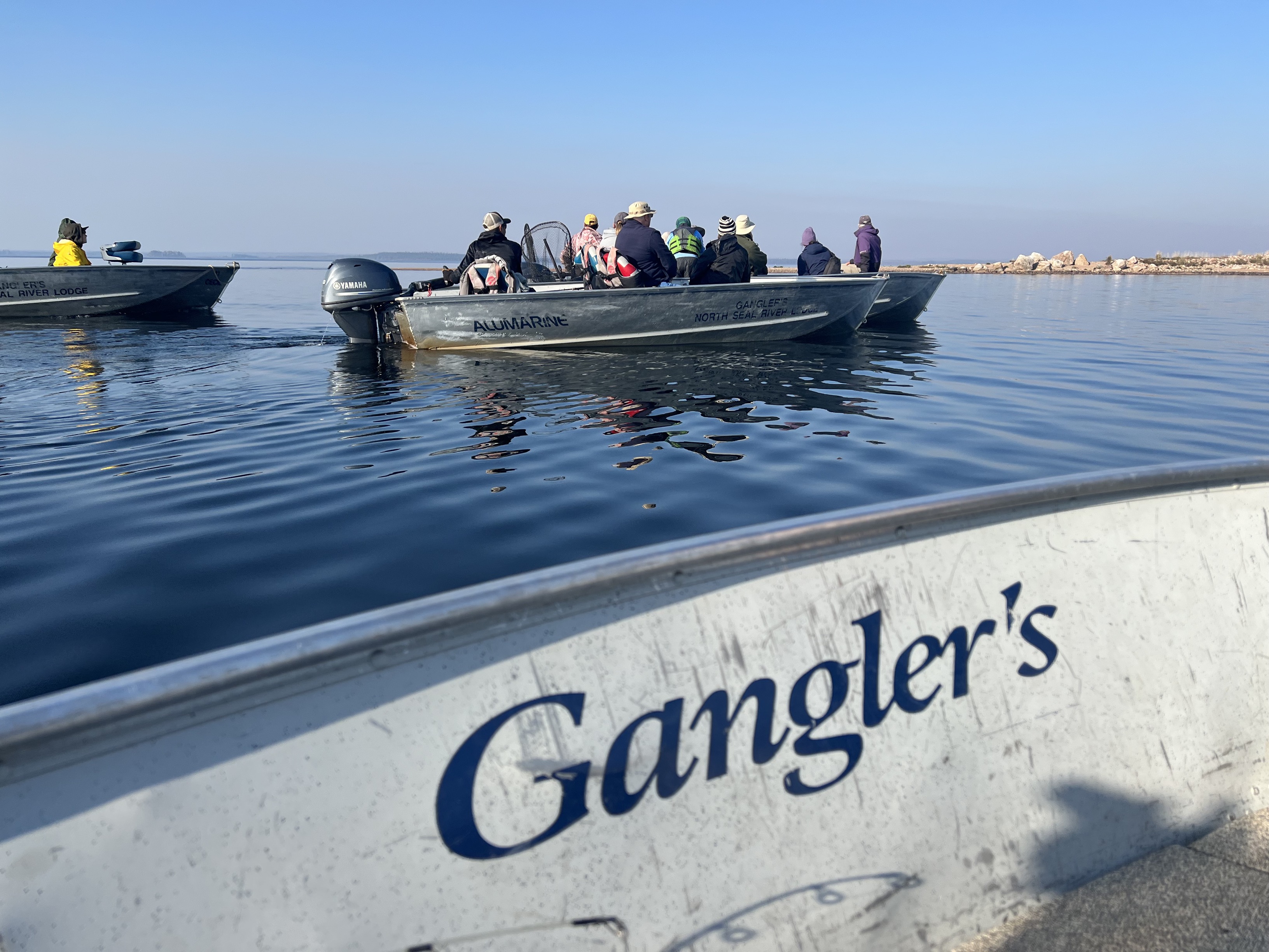 A gangler's boat is on the water with people in it