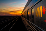 Side view of a VIA Rail sleeper train as the sun sets  