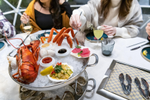 A group of people enjoying a lobster dining experience at Shuck Seafood + Raw Bar in Halifax 