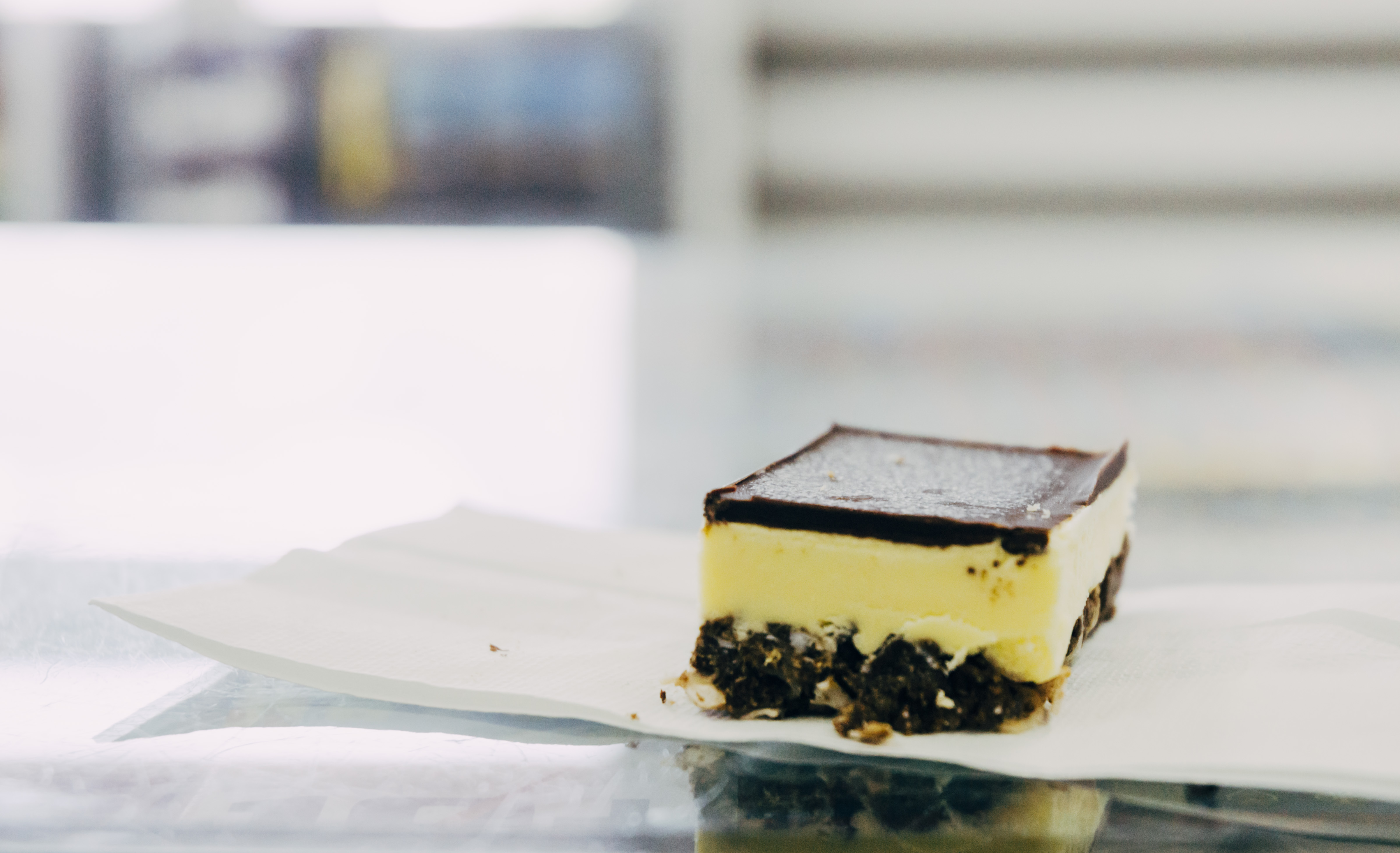 A close-up shot of a Nanaimo bar on a napkin
