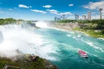 sunny day at Niagara Falls, tourist boat with passengers on water