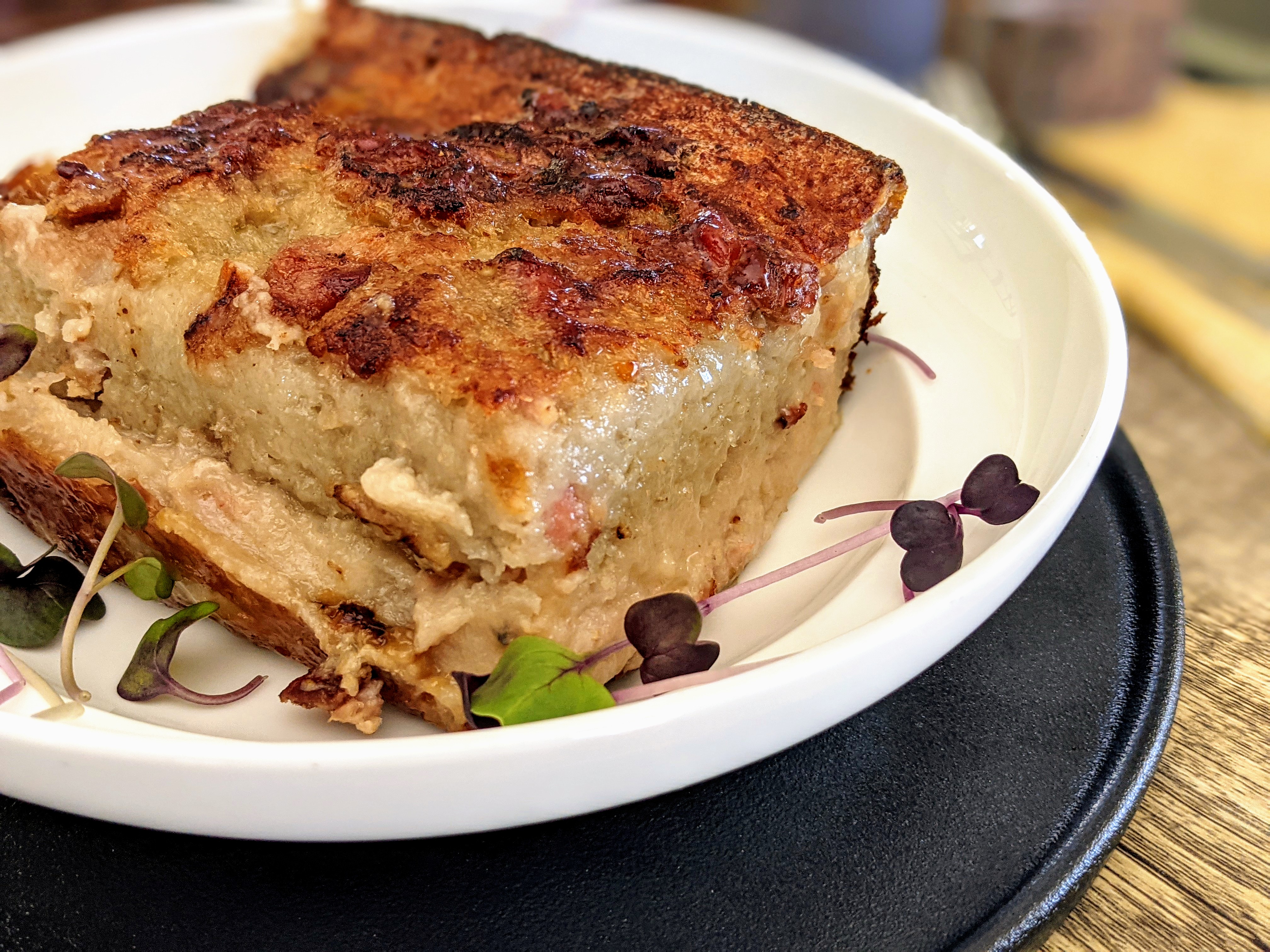 A close-up shot of a piece of Rappie Pie plated with leaves as embellishment