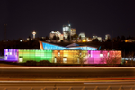 TELUS Spark colourful building exterior at night with Calgary skyline in the background