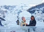 Couple cheersing on frozen Lake Louise with ice sculpture