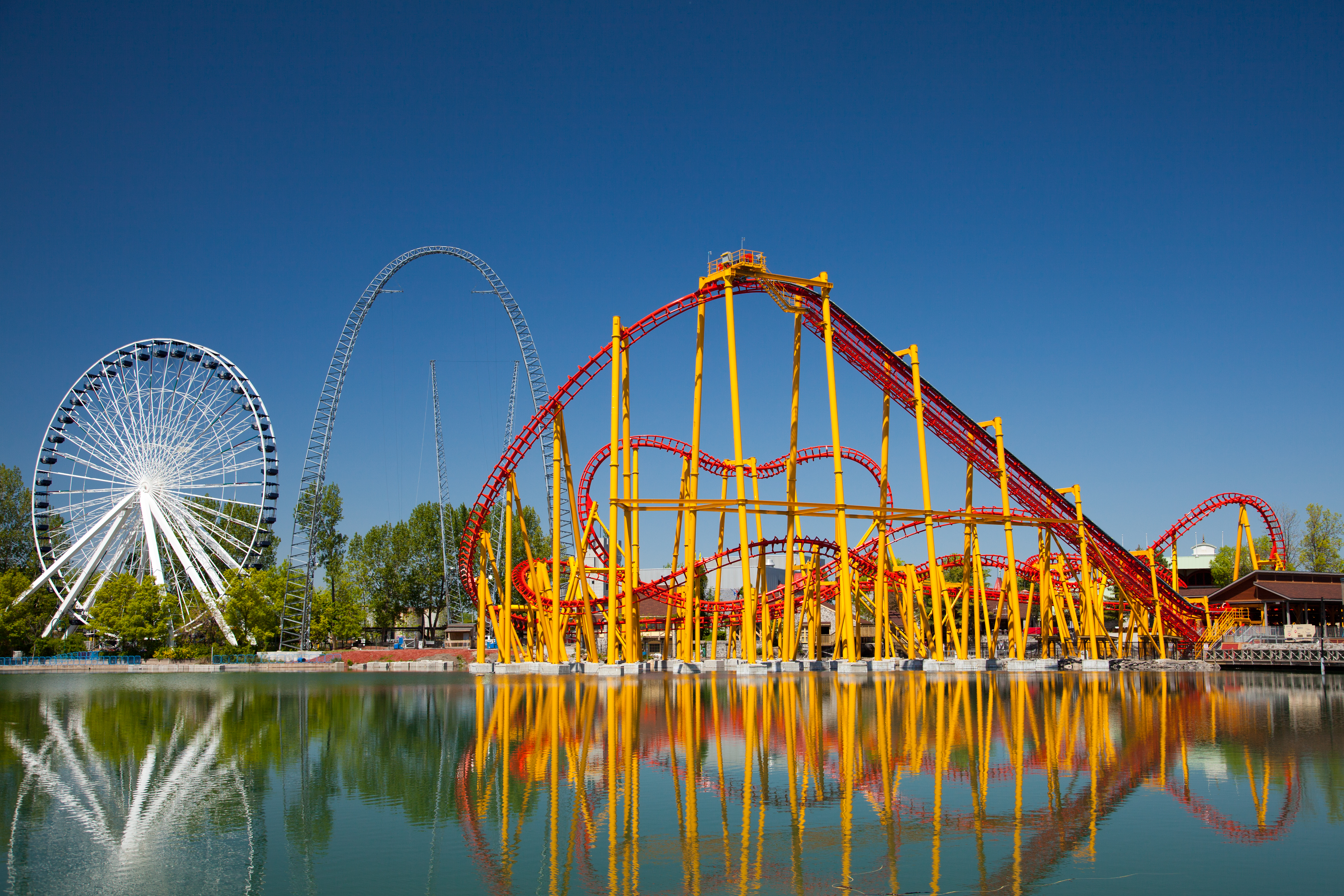 Large twisting rollercoaster and ferris wheel next to the water in Montreal