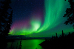 Impressive Aurora display spreads across starry sky and above body of water in Canada’s Northwest Territories 