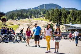 A family walks past the gondola in Whistler in the summertime