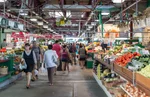 People walk past vegetable stands in the Jean-Talon Market