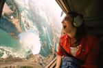 A woman beams while flying over the Niagara Falls in a helicopter