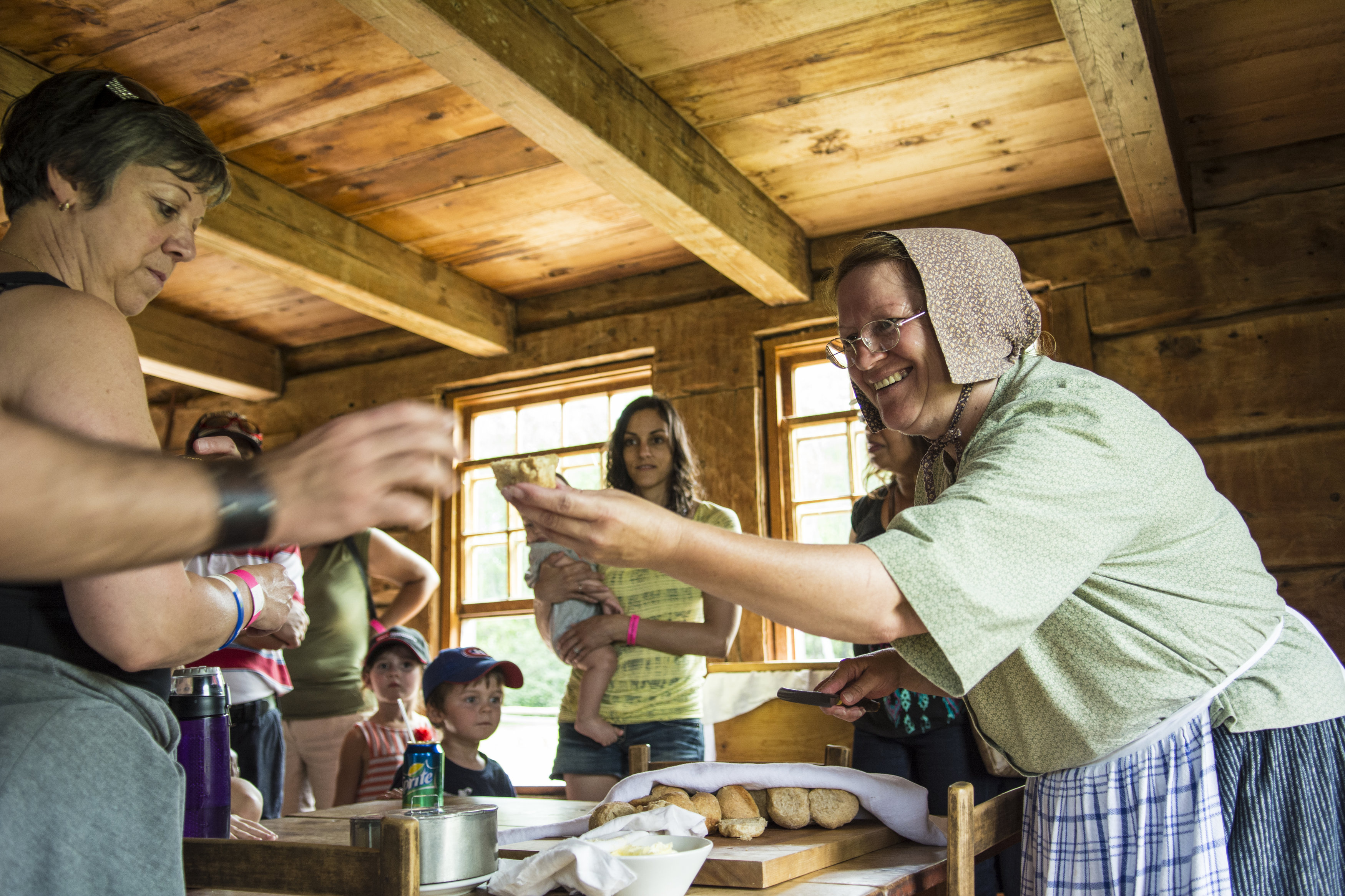 Visitors participate in immersive experience with actors in period costume portraying Acadian lifestyle from past centuries