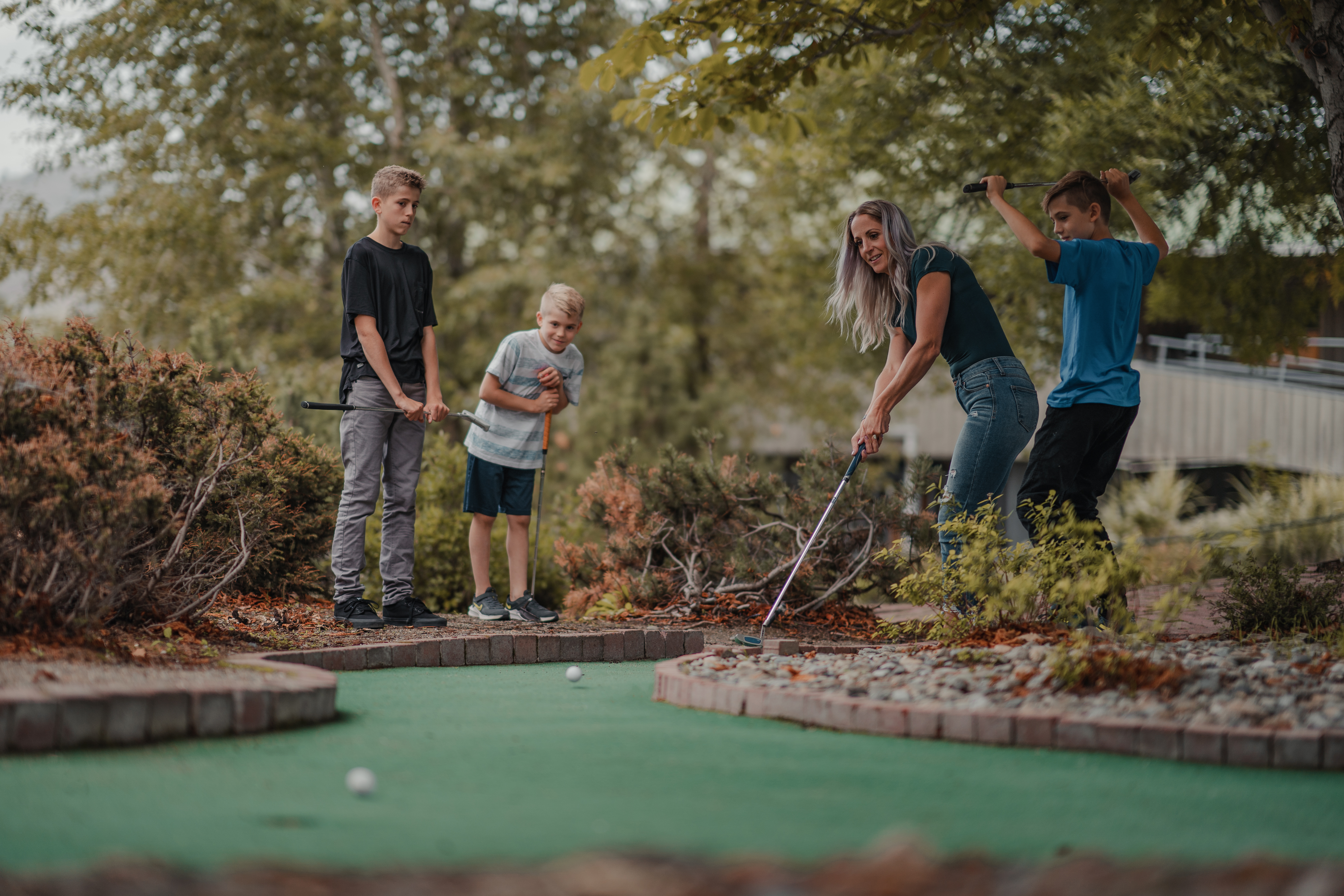 A woman and three young boys playing mini golf in Kamloops