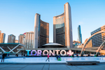 People ice skating in front of the Toronto Sign on a clear day in winter