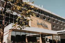 Inn at the Forks hotel exterior, low-rise building with tree on the left side