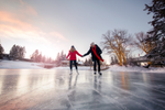 Couple holding hands as they skate on the frozen lagoon in Bowness Park