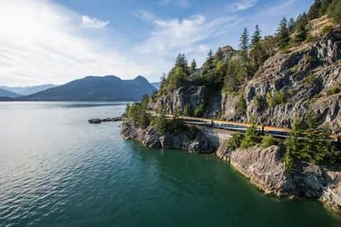 The Rocky Mountaineer Train travels along the ocean on the Sea to Sky