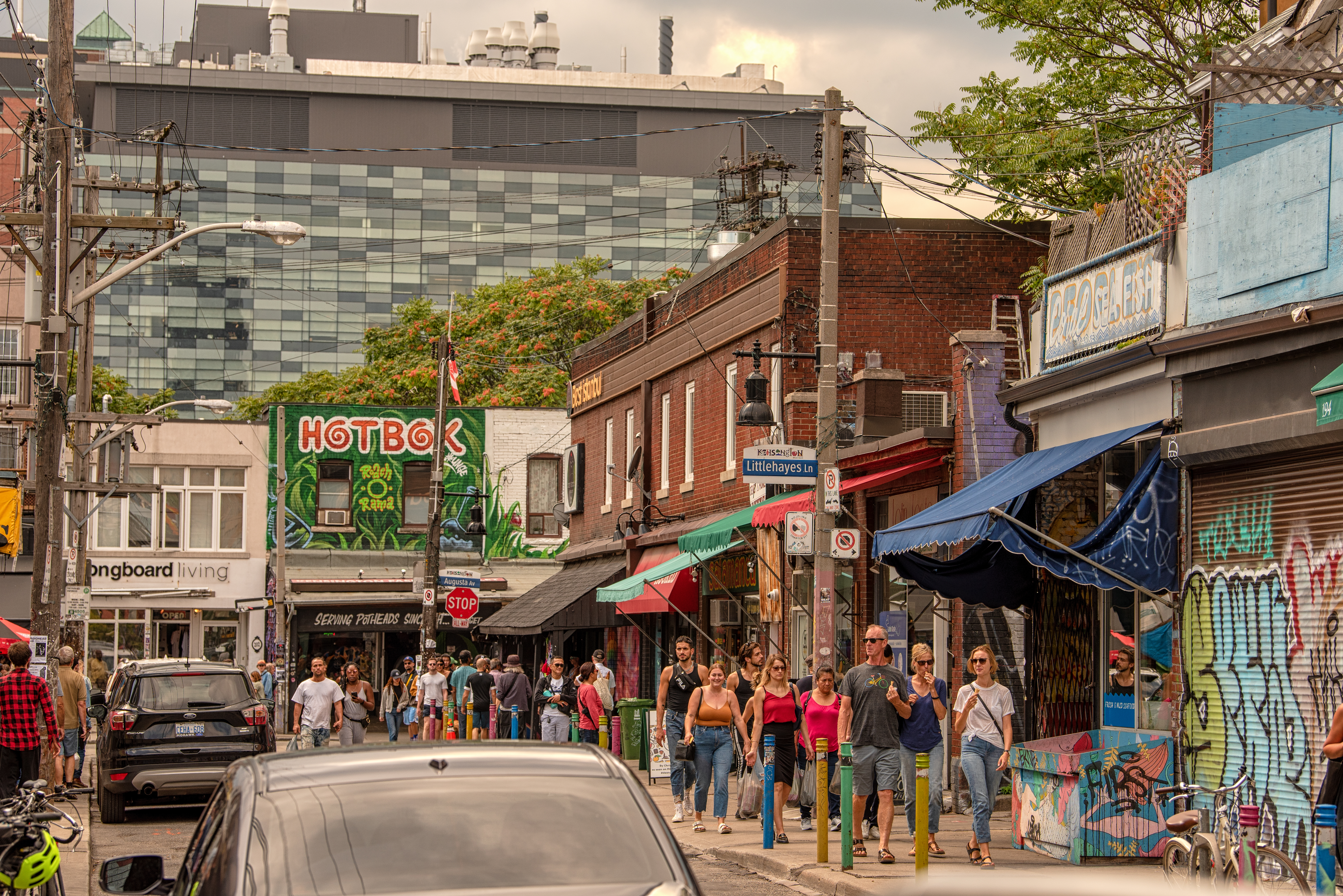 People walking along a busy street corner in Kensington Market neighbourhood
