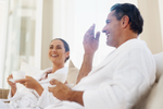 couple smiling and enjoying a hot drink in spa robes at a day spa