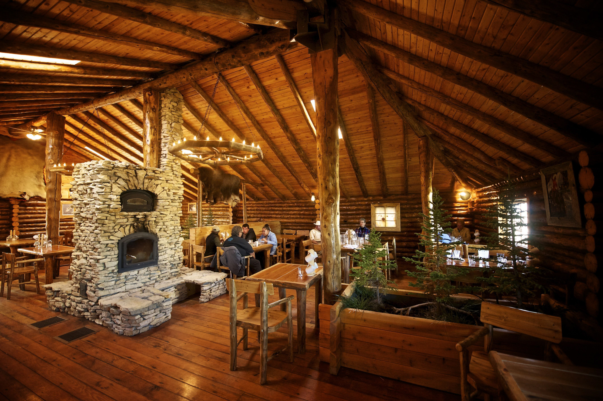 Log cabin interior with stone fireplace built from timber and Douglas Fir of Lazy Bear Lodge in Churchill, Manitoba