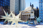 Statue and winter star decorations in Place D'Armes in snowy Montreal
