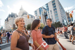 Three people walk across a street in downtown Ottawa on a summer’s day