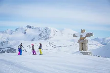 family of skiers on snowy mountain ski run in Whistler, Inukshuk